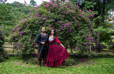 Casal medieval passeando pelos jardins do castelo