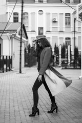 woman in yellow coat walking on city street