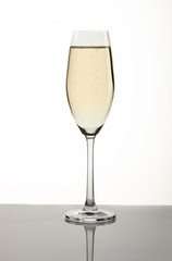Glass with champagne on a white background with a gray substrate