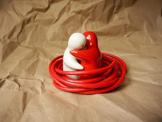 Connection as a concept. Two figures like people in hugs trapped with knotted wire