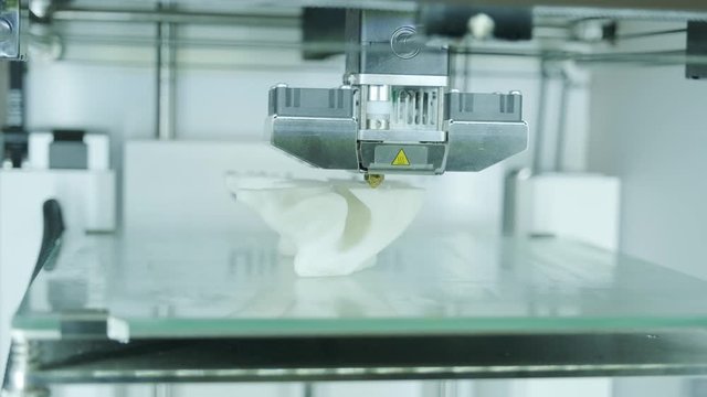 Modern 3D printer printing figure close-up macro.Automatic three dimensional 3d printer performs plastic white color modeling in laboratory. 3d-printing processing with white background