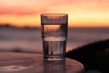 glass of water at sunset on the sea