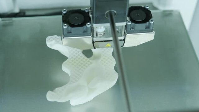 Modern 3D printer printing figure close-up macro.Automatic three dimensional 3d printer performs plastic white color modeling in laboratory. 3d-printing processing with white background