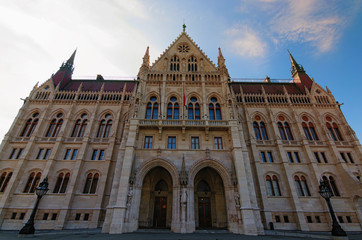 Fototapeta premium Wide angle landscape view of building of Parliament in Budapest. It is one of europe's oldest legislative buildings. Colorful vibrant sky in the background. Budapest, Hungary