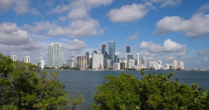 A slow motion tracking shot of the iconic Miami skyline on a sunny summer day.  	