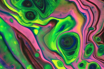 Neon pink, yellow, and green dance with classic blue and black in this abstract background.