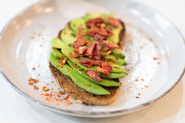 Sliced fresh avocado toast bread with spices. Healthy vegan or vegetarian breakfast. Whole nutritional food