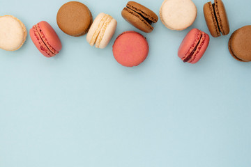 Macarons cakes. Abstract food photo background with delicious macaroons over blue background. Flat lay social media walpaper. Copy space.