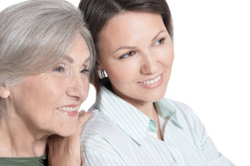 Close up portrait of mother and her adult daughter hugging isolated on white