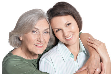 Close up portrait of mother and her adult daughter hugging isolated on white