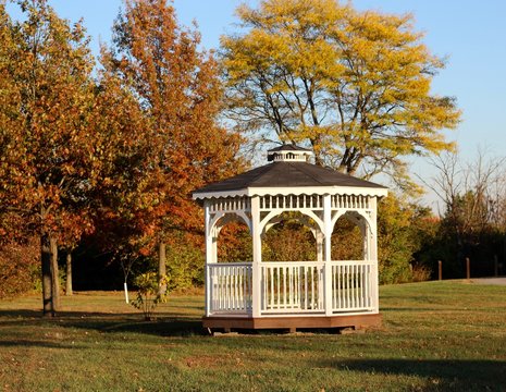The white gazebo in the park on a sunny fall evening. - Powered by Adobe