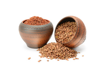 Lentils and brown rice in clay pots isolated on white background.