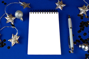 Christmas, winter composition. Notebook with isolated white page, open diary, sketch book mock-up scene on blue surface.