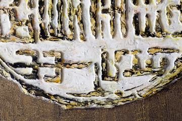 A fragment of the relief in the spirit of Chinese characters - white and gold. Ancient text