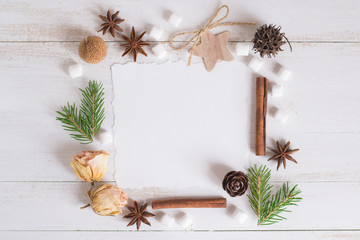 Christmas composition. Paper, cones, fir tree branches, roses, star, anise on white background. Top view, flat lay, copy space.