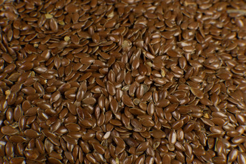 Linum usitatissimum is scientific name of Brown Flax seed. Also known as Linseed, Flaxseed and Common Flax. Closeup of grains, background.