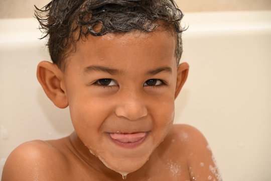 Toddler sticks his tongue out at bathtime