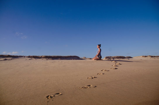 Girl practicing yoga on the beach