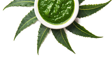 Medicinal Neem leaves with paste in bowl on white background.