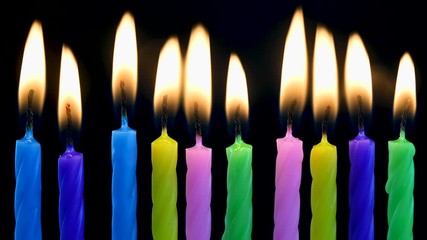 Burning birthday candles on black background