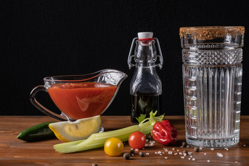 Fresh organic tomato juice decorated with raw tomatoes, leaves on a dark rustic wooden background. Healthy diet nutrition concept. 