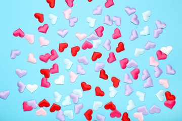 Colorful small hearts on blue background