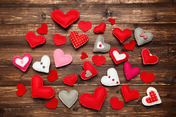 Fototapeta premium Colorful fabric hearts on brown wooden table