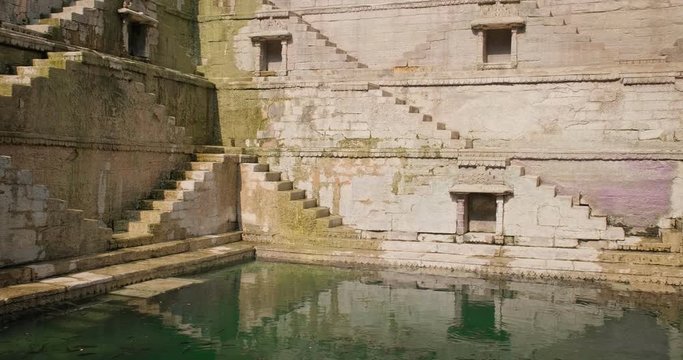 Water storage inside Toorji Ka Jhalra Baoli and stepwell - one of water sources in Jodhpur, Rajasthan, India. Horizontal pan