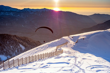 Paragliding at sunset in winter in the mountains.