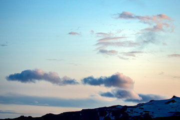 Beautiful clouds over the hilly landscapes of Iceland. Nature and places for wonderful travels