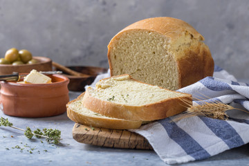 Fresh homemade crisp bread  and slices with olive oil, butter and green olives, top view.  Baking concept