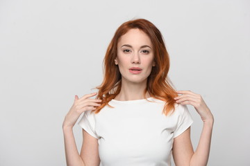 portrait of young woman, isolated on white. Red hair, beautiful eyes and lips, model appearance, waist-length shot in light beidge-white dress with short sleeves