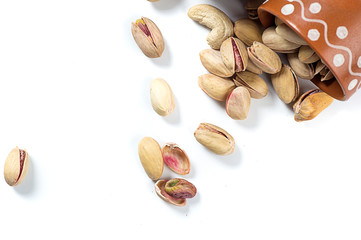 Pistachio and Cashew Nuts in clay pots on white background