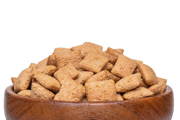 Cereal pillows dry breakfast in wooden bowl