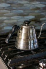 Kettle on a stove to make pour over coffee.