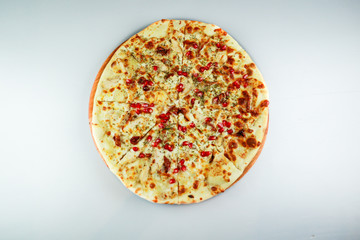 Smoked pizza. chicken, pomegranate berries and cheese. Wooden plate. Gray background. Restaurant