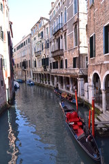 Fototapeta na wymiar Traditional venetian cityscape. View of the canal, ancient buildings and the gondola.