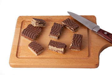 chocolate wrafer biscut on wooden cutting board with knife