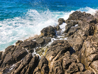 Sea waves and rocks. Background on the theme of tourism, sea travel. The coast of the Mediterranean Sea.