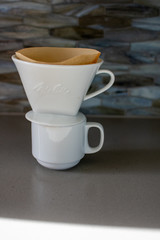 making pour over coffee with a stainless steel kettle on a gas stove