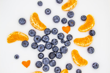 Fresh blueberry  with mandarin slices on white background. A composition of the blueberries and mandarin pieces which is organic and healthy. The berries and fruit full of vitamins.