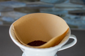 making pour over coffee with a stainless steel kettle on a gas stove