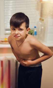 Teenager Boy 10 Years Old Holding On To His Stomach, Emotion Of Facial Pain, Sore Stomach, Ulcer. Disease Concept. Hospitalization