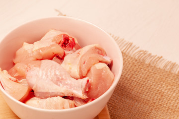 raw chicken in bowl on jute cloth background