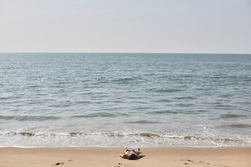 Fototapeta na wymiar A girl sunbathes on a beach in India. Arambol, GOA