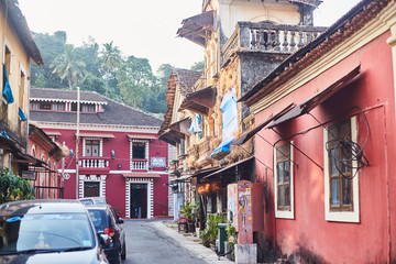 Panaji, India - December 15, 2019: A narrow lane surrounded by colorful portuguese houses in Panjim, Goa - obrazy, fototapety, plakaty