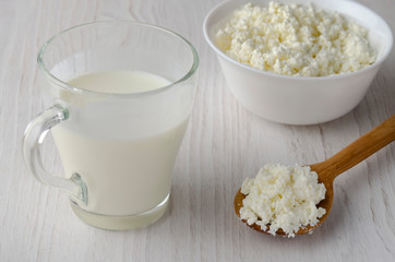 A glass bottle with kefir and kefir grains with bread rolls on the wooden table