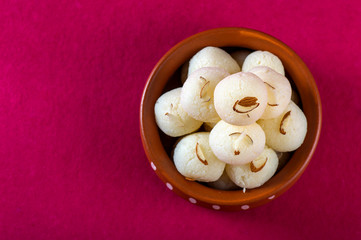 Indian Sweet or Dessert - Rasgulla, Famous Bengali sweet in clay bowl on a pink background.