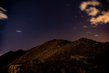 night mountain landscape with sky, clouds and stars
