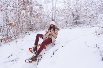 A young woman rides a sledge 